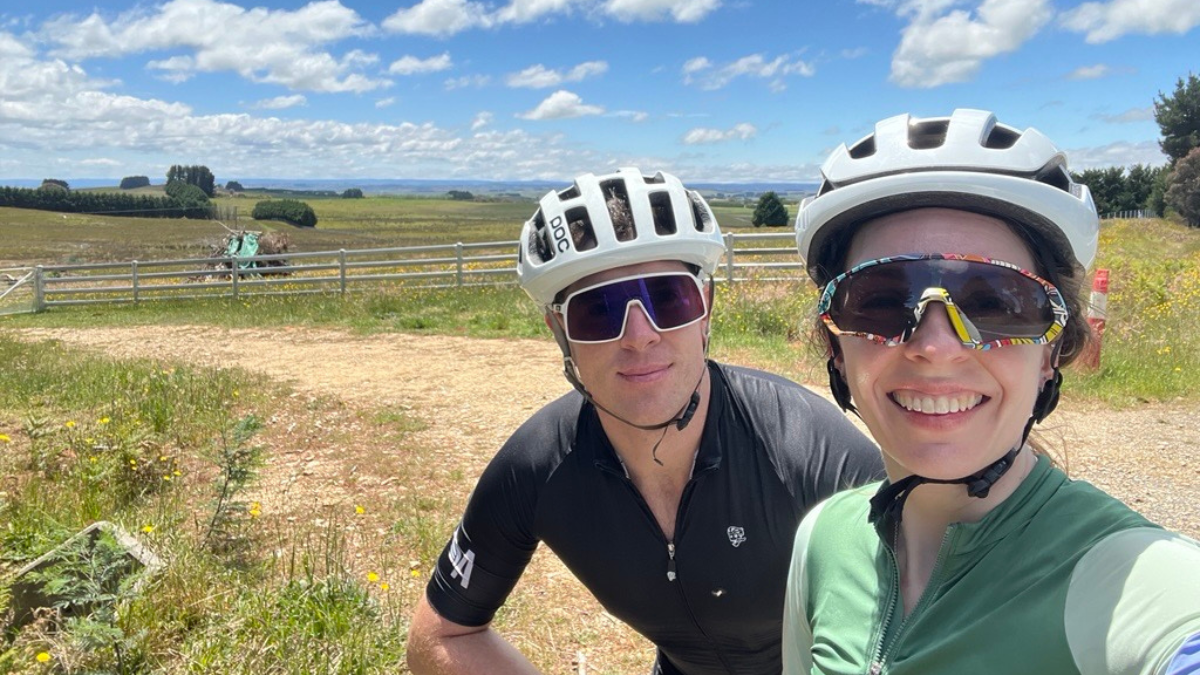 Rebecca Martin and her partner wearing bike helmets on a bike trail.