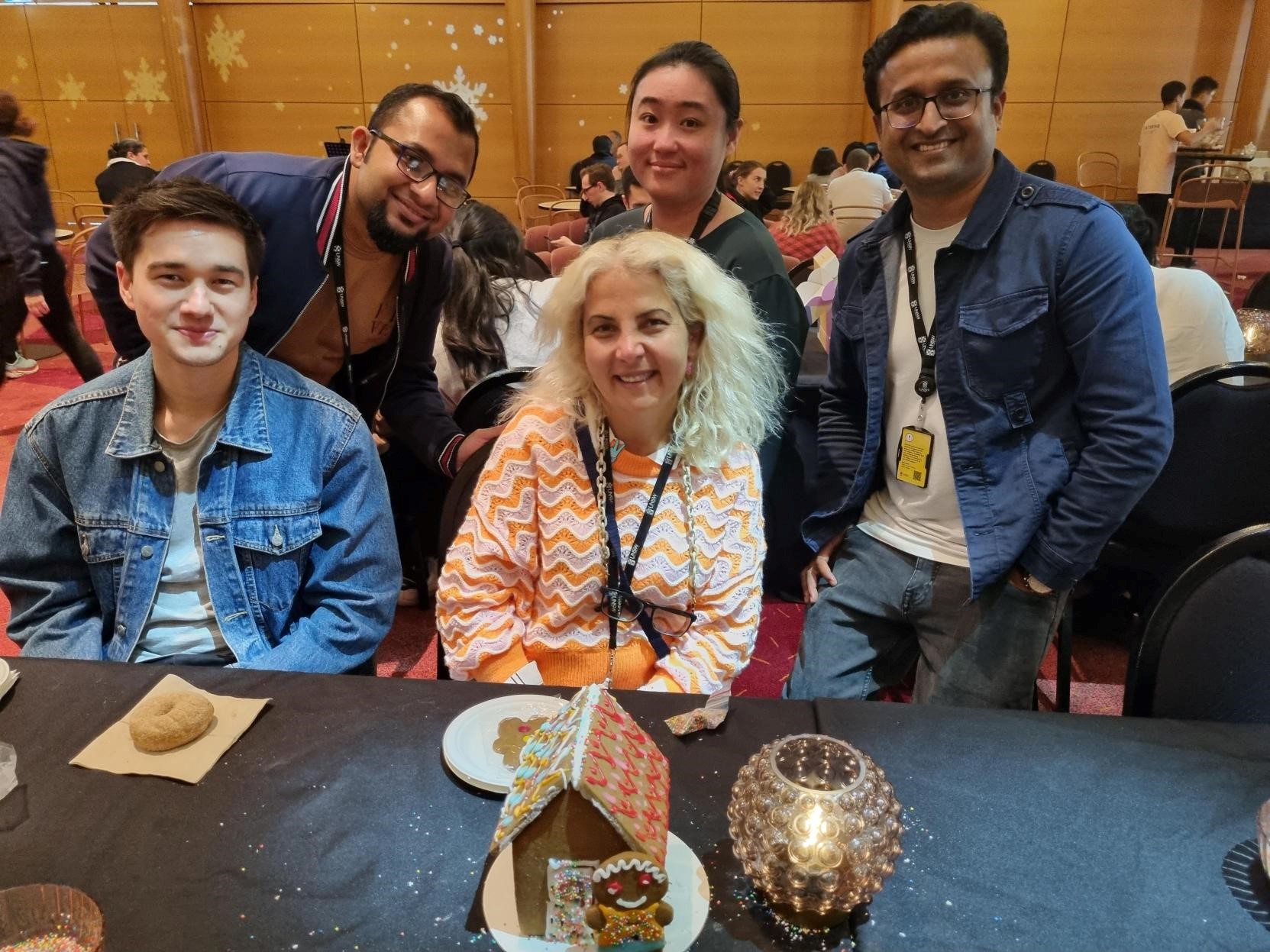 A group of UNSW staff with a gingerbread house