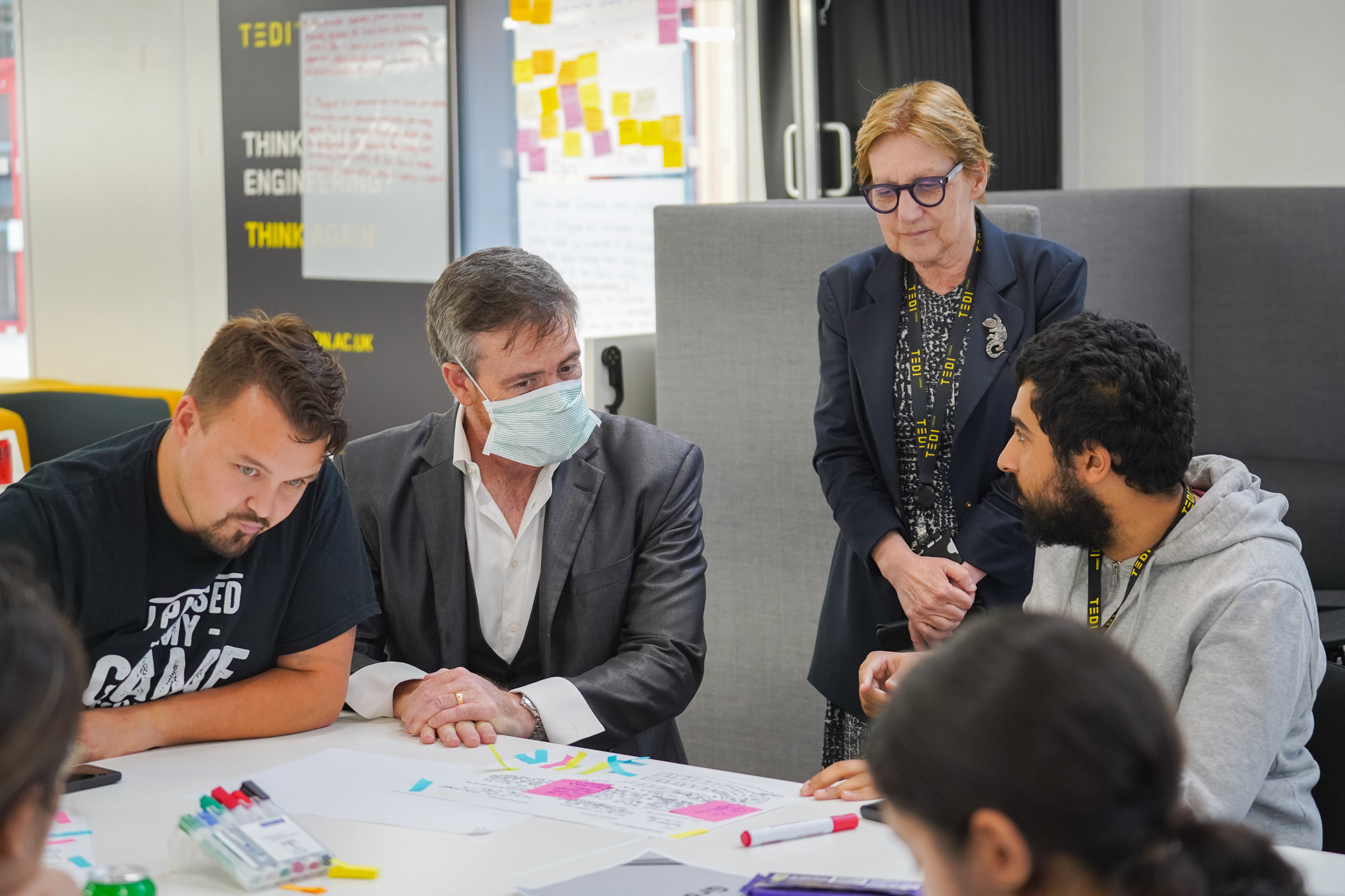 Vice-Chancellor and President Atilla Brungs and Professor Judy Raper, Dean and CEO of TEDI-London, with students at a table 