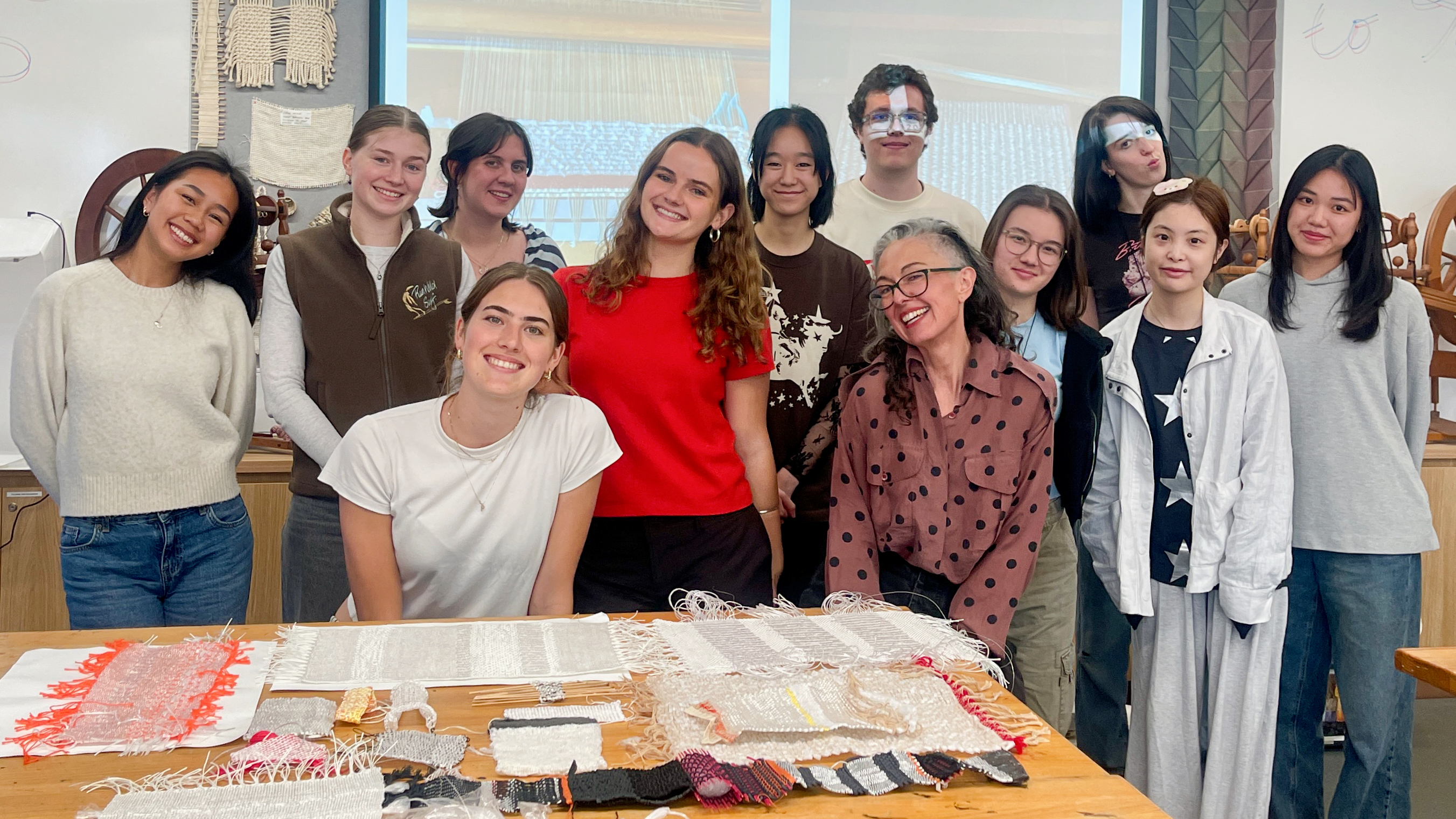 A group of people in a textile studio smiling at the camera