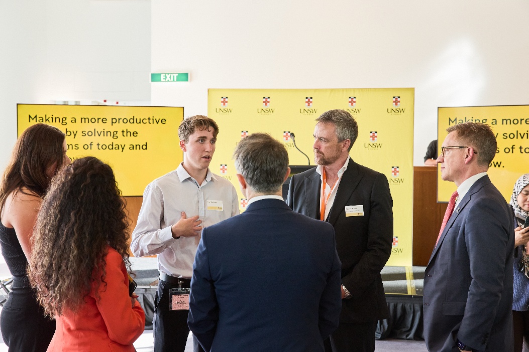 A group of people standing in front of a yellow sign
AI-generated content may be incorrect.