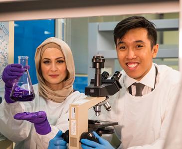 Two smiling researchers in a laboratory