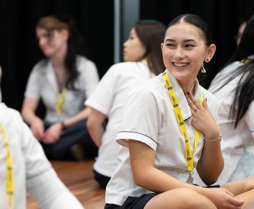 A high school student smiling at another student