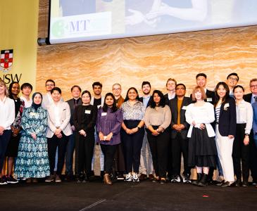 3 minute thesis participants posed on stage with the Vice-Chancellor