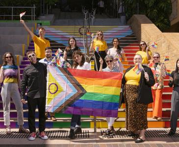 UNSW staff gathered at the Basser Steps with rainbow flags