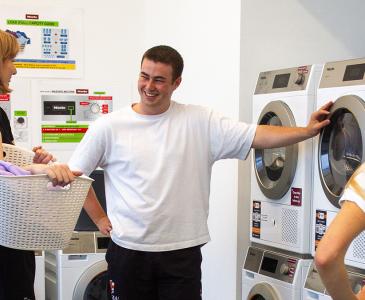 A group of student gathered in the laundry room at Colombo House