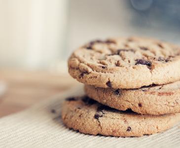 three chocolate chip cookies on a bench