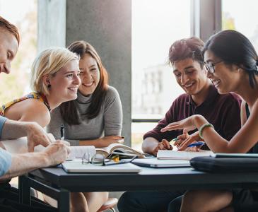 A group of uni students having a discussion around a table