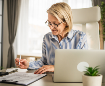 A woman writing her Will at a desk.