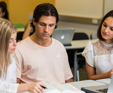 Three students in discussion in the classroom