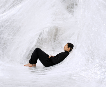 A woman wearing all black cocooned in a white web
