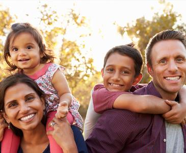 A family of four, outdoors in a park