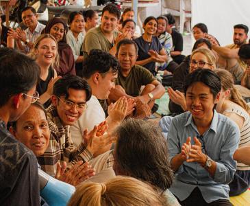 A group of people clapping and smiling