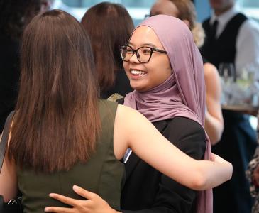 Two students embracing and smiling