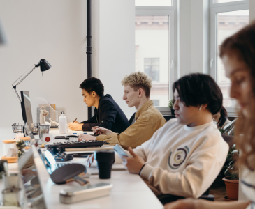 Four staff members sitting a desk working