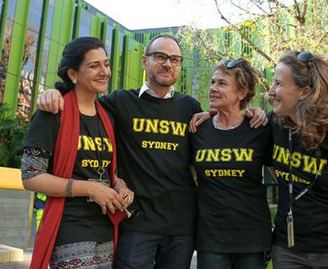 Four smiling people standing in front of Wallace Wurth building