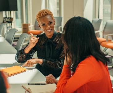 Two women talking in a boardroom