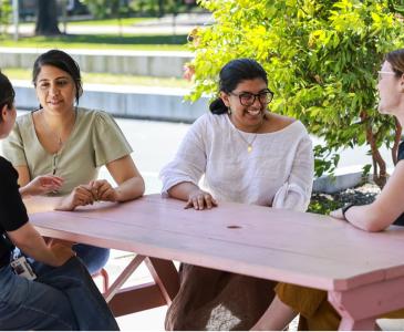 A group of women at a table outside talking