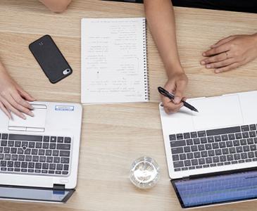 Two laptops on a wooden table