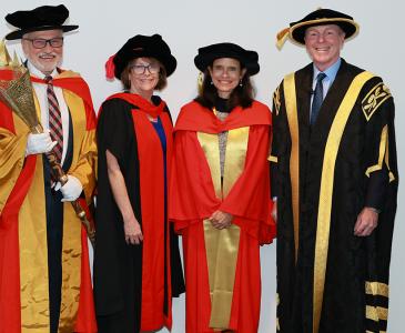 Four people in academic regalia