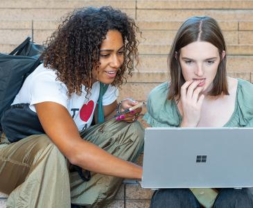 Two students looking at a laptop