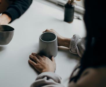 Two people sitting at a table with coffees