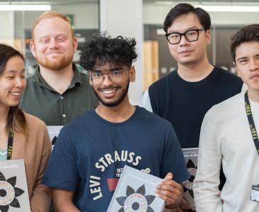 Five students pose with a book titled "Innovation is beautiful"