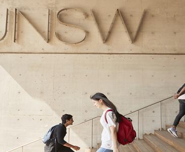 Students walking past UNSW sign