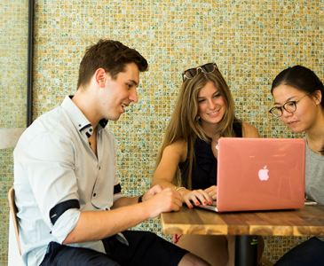 Three UNSW students sitting around a laptop