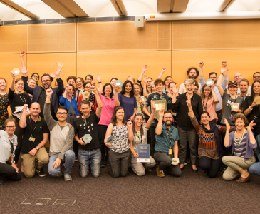 A crowd of Green Impact participants waving