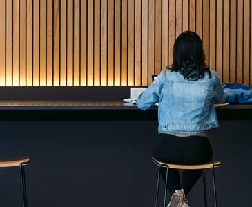 Woman sitting on a stool at a bench