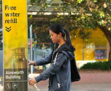 student filling up water bottle at refill station