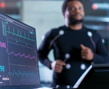 A man on a running machine with monitors attached 