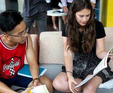 Two students reading a booklet