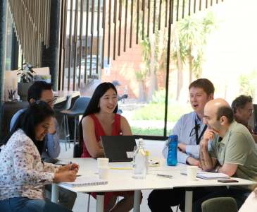 A group of people gathered at a table having a discussion