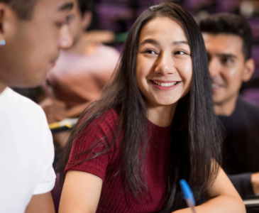 Three students in class smiling