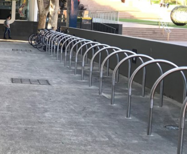 curved metal bike racks on a concrete ground