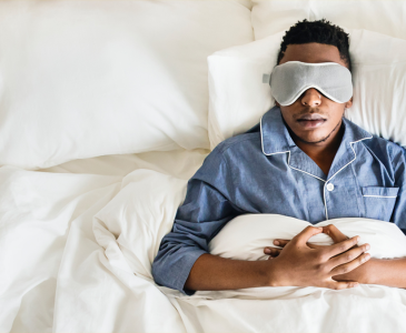 A man sleeping with an eye mask