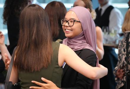 Two students embracing and smiling