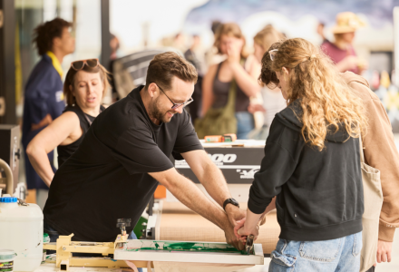 A man helping people screenprint