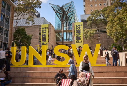 UNSW's Kensington Campus with a large, yellow UNSW statue and Progress For All posters