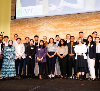 3 minute thesis participants posed on stage with the Vice-Chancellor