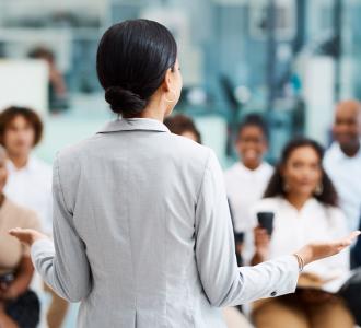 Woman giving presentation to group of staff