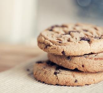 three chocolate chip cookies on a bench