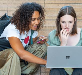 Two students looking at a laptop