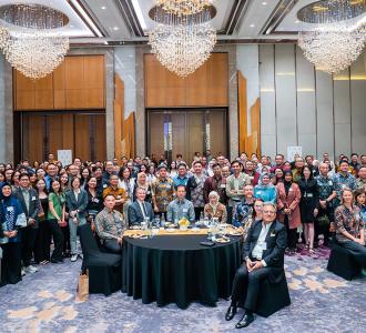 A large group of people posed in a grand room