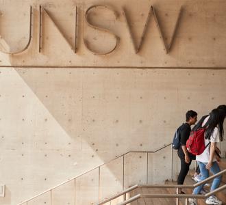 People walking up steps with UNSW logo in backgroun