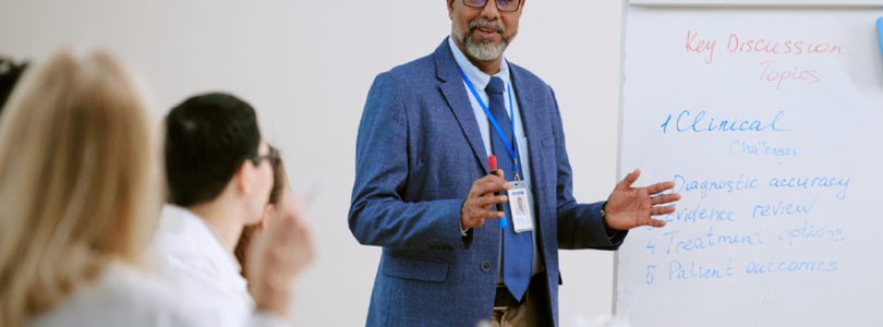 A man standing at a white board in front of a group of people