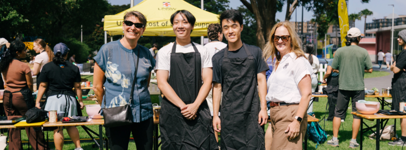 Four people from Arc standing in front of cooking materials on the UNSW campus.